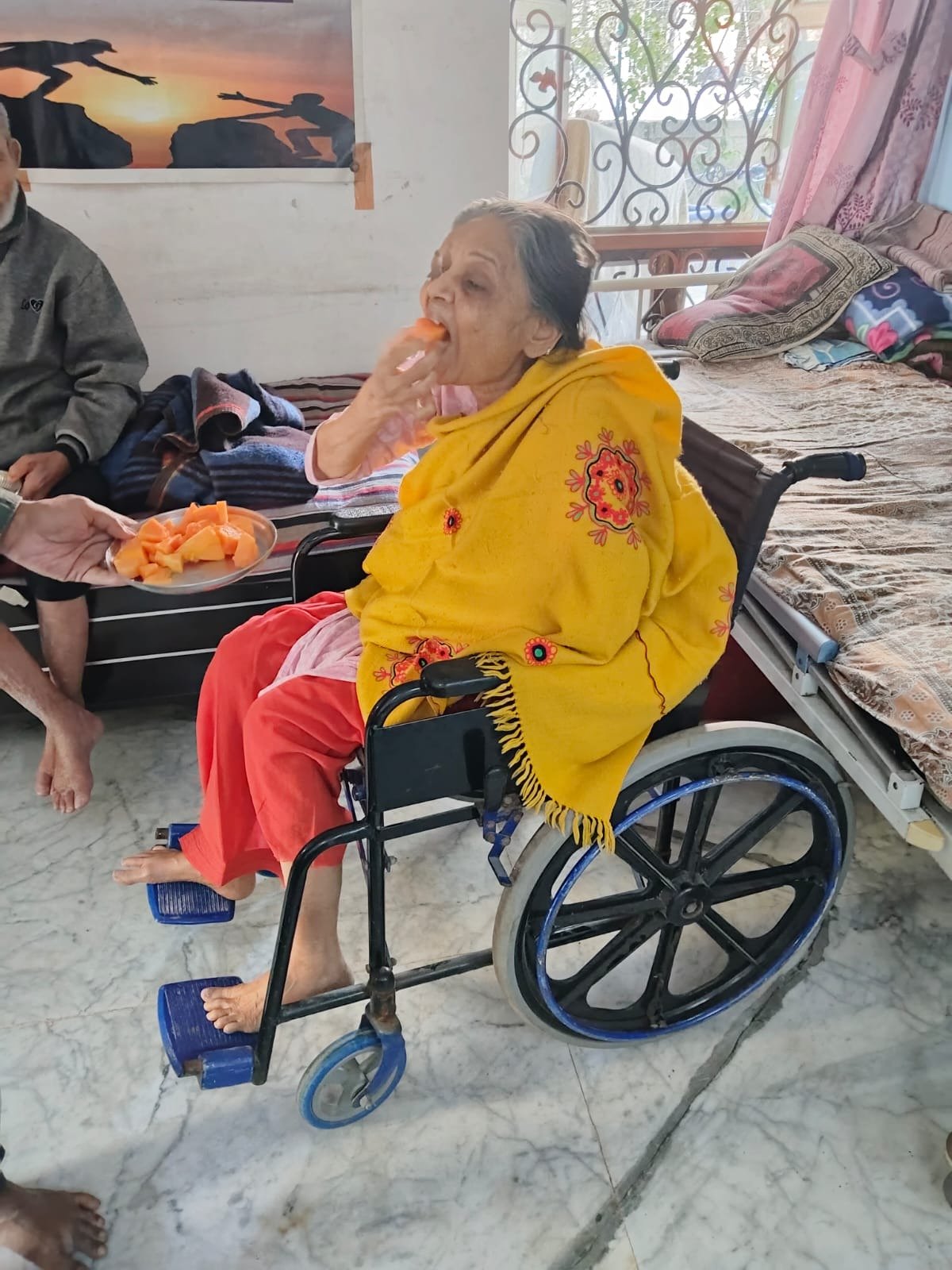 વ્હીલચેરમાં બેઠેલા વડીલ ફળ ખાતા